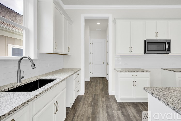 A kitchen with white cabinets and a granite countertop.