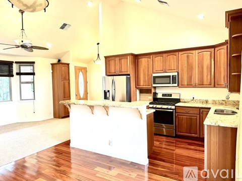A kitchen with wooden cabinets and a white island.