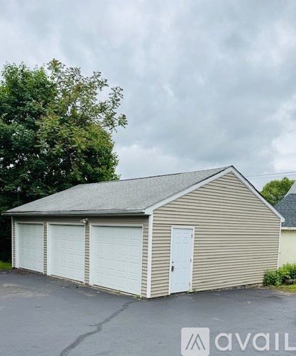 A two-car garage with a beige siding and a white door is available for rent.