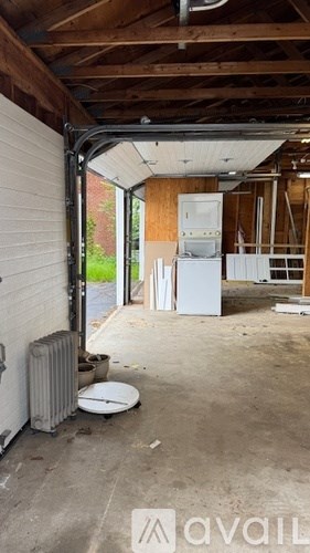 A room with a white fridge and a radiator.