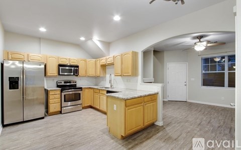A kitchen with wooden cabinets and stainless steel appliances is available for rent.