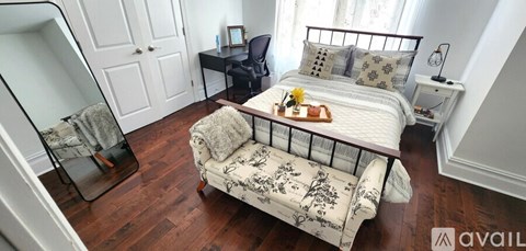 A bedroom with a four poster bed and a chair.