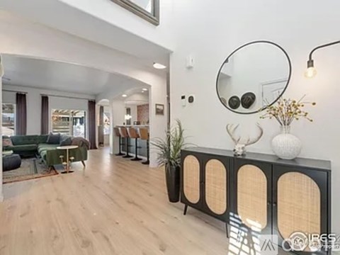 A living room with a green sofa and a wooden floor.