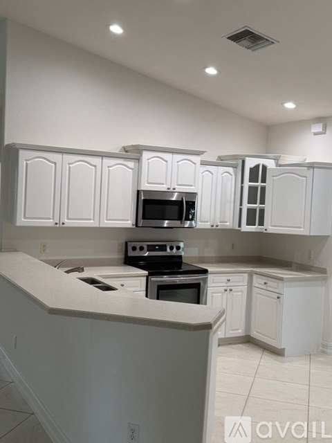 A kitchen with white cabinets and appliances.