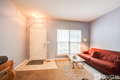 A living room with a red couch and a coffee table.
