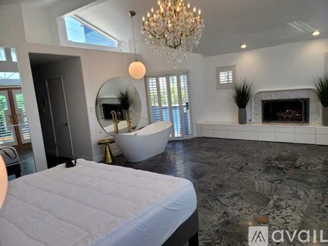 A bedroom with a large bed and a chandelier.