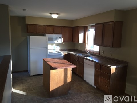 A kitchen with brown cabinets and a white refrigerator.
