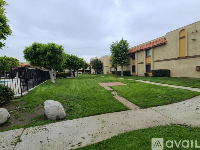 A grassy area with a pathway and a building in the background.