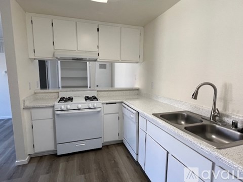 A kitchen with white cabinets and a stove top oven.