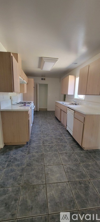 A kitchen with wooden cabinets and a tiled floor.