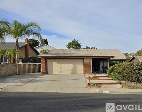 A house with a garage and a driveway in front of it.