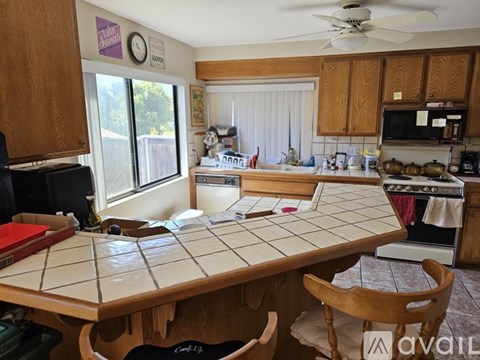 A kitchen with a table and chairs in the foreground and a microwave and oven in the background.