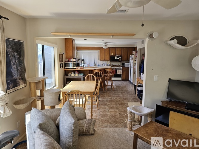 A living room with a couch, chairs, and a television.