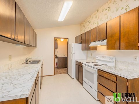 A kitchen with white appliances and wooden cabinets.