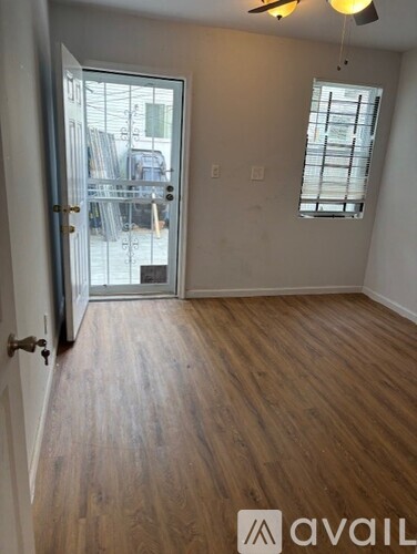A room with wooden flooring and a ceiling fan.