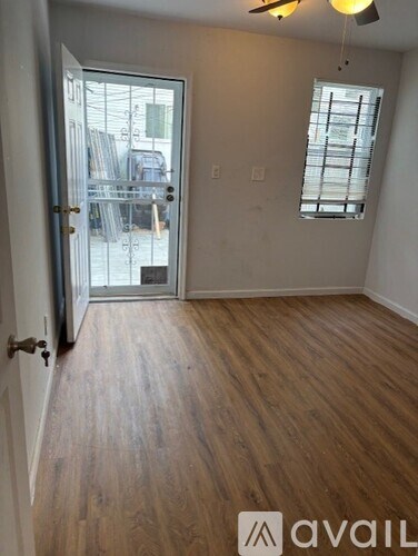 A room with wooden flooring and a ceiling fan.