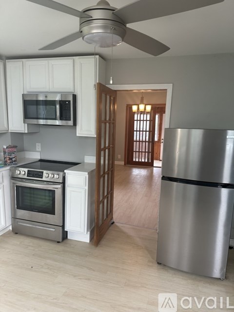 A kitchen with a stainless steel refrigerator and a stove top oven.