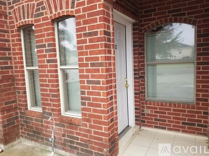 A red brick house with a white door and windows.