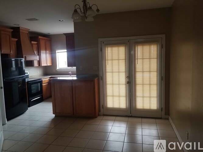 A kitchen with wooden cabinets and black appliances is available for rent.