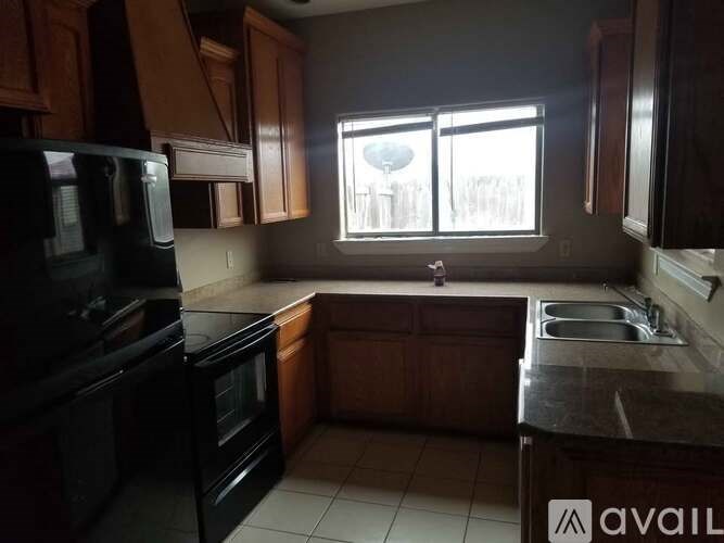 A kitchen with black appliances and wooden cabinets.