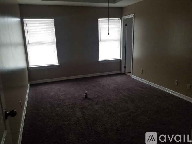 A room with a carpeted floor and a door on the left side.