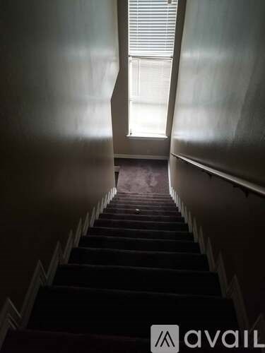 A staircase leading to a brightly lit window.
