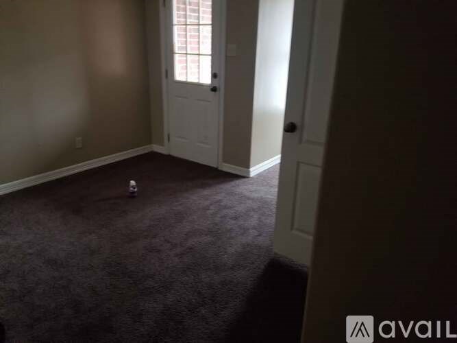A room with a carpeted floor and a white door.