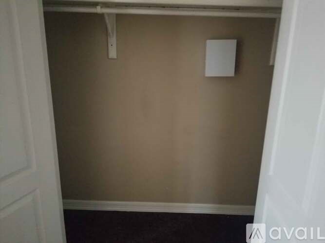 A wall with a white door and a white switch on it.