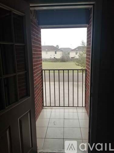 A view from a doorway looking out to a balcony with a metal railing.