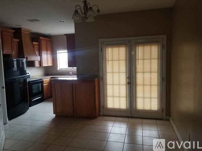 A kitchen with black appliances and wooden cabinets.