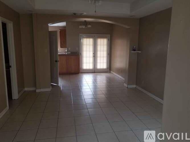 A spacious room with tile flooring and a window letting in natural light.