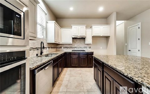 A kitchen with white cabinets and a granite countertop.