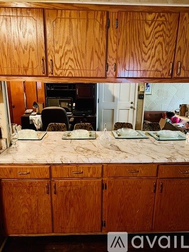 A kitchen with wooden cabinets and a marble countertop.