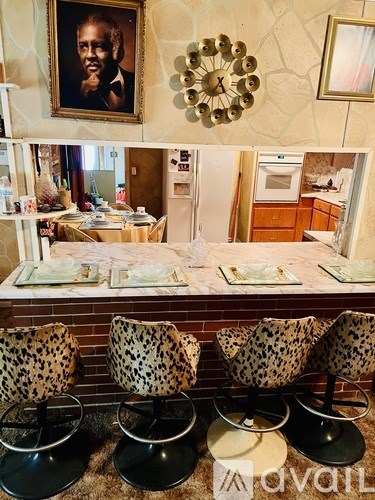 A dining area with leopard print chairs and a marble table.