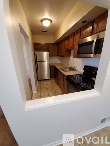 A kitchen with a stainless steel refrigerator and a black stove top oven.