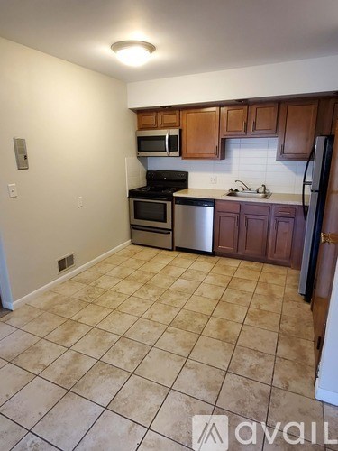 A kitchen with brown cabinets and a tile floor.