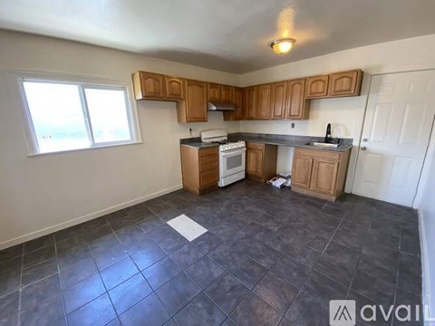 A kitchen with wooden cabinets and a tiled floor.