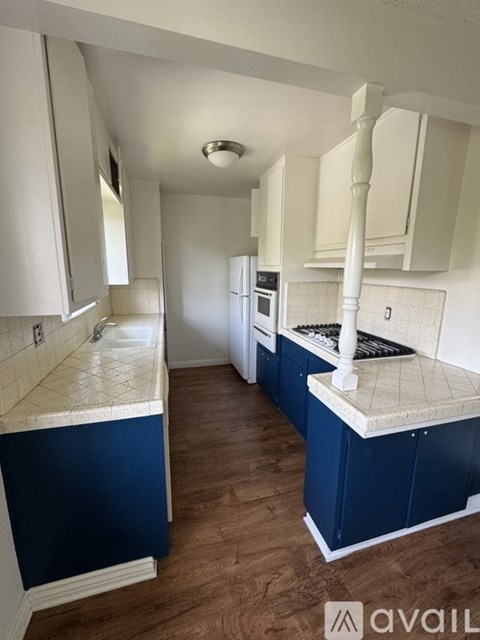 A kitchen with blue cabinets and a white countertop.