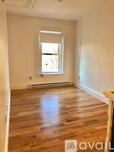 A room with wooden flooring and a window.
