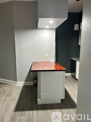 A kitchen with a white cabinet and a wooden top.