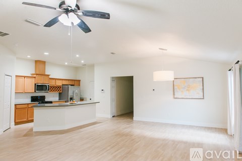 A spacious kitchen with wooden cabinets and a white countertop.