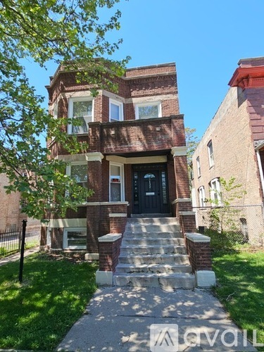 A brick house with a black door and steps leading up to it.