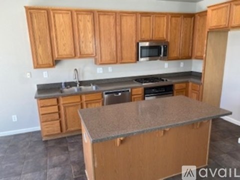 A kitchen with wooden cabinets and a granite countertop.