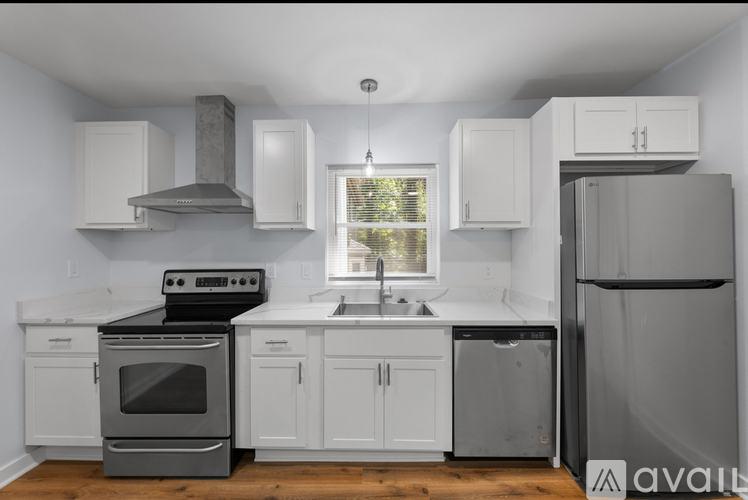 A kitchen with white cabinets and a black stove top oven.