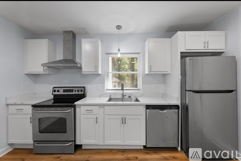 A kitchen with white cabinets and a black stove top oven.
