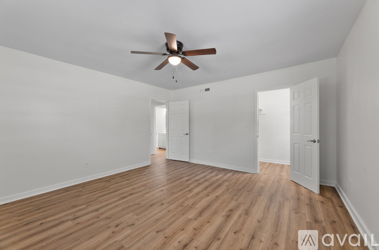 A room with wooden floors and a ceiling fan.