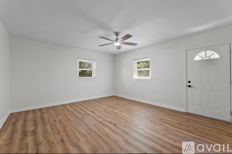 A room with wooden flooring and a ceiling fan.