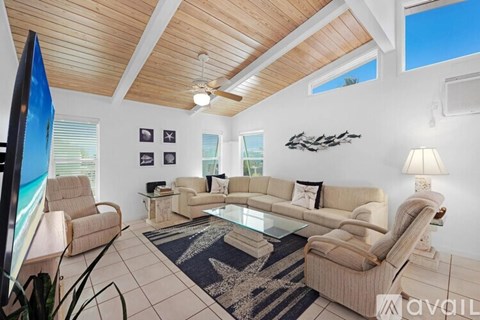 A living room with a sofa set, a coffee table, and a television.