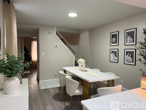 A dining room with a white table and chairs.
