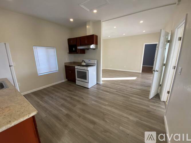 A kitchen with a white fridge, white oven, and wooden cabinets.